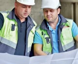 Two construction workers looking at a architectural plan