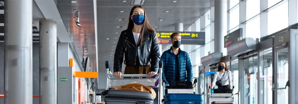 Personen auf dem Flughafen mit Schutzmasken