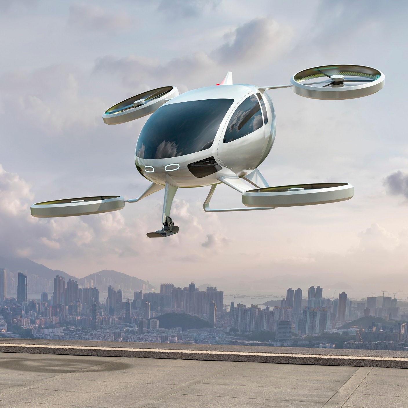 A generic white electric powered Vertical Take Off and Landing eVTOL aircraft with four rotors, coming in to land on roof top.