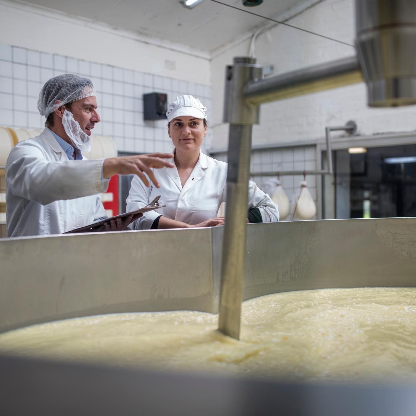 Business continuity management in the food industry - Cheese factory workers controlling curdling process