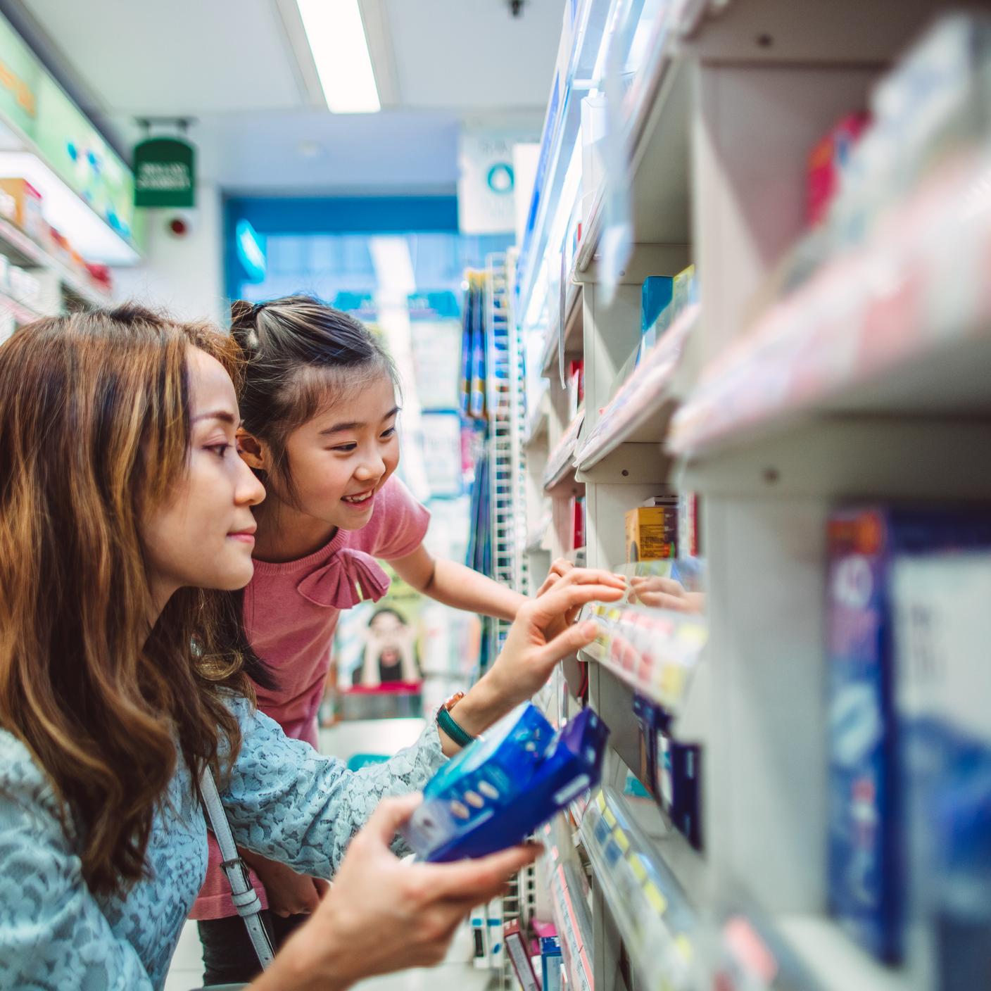 Future of trust - Pretty young mom shopping with her lovely daughter in a drugstore joyfully