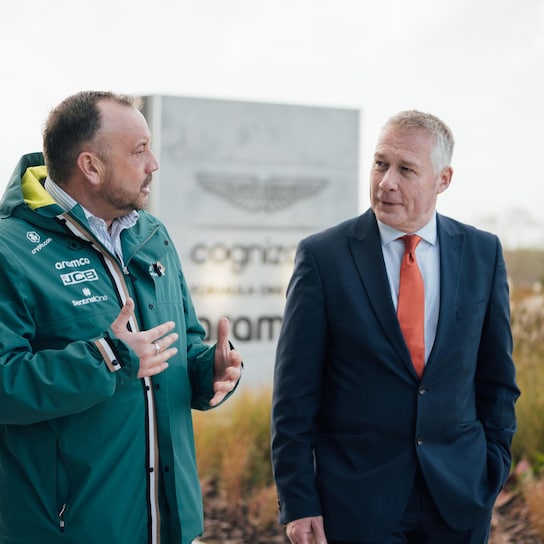 Two men talking infront of Aston Martin building