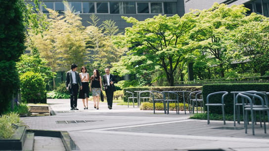 Des gens d’affaires marchent dans les jardins d’un bureau