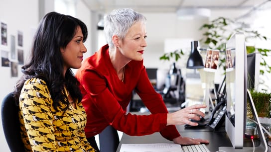 Mature business woman mentoring younger employee.