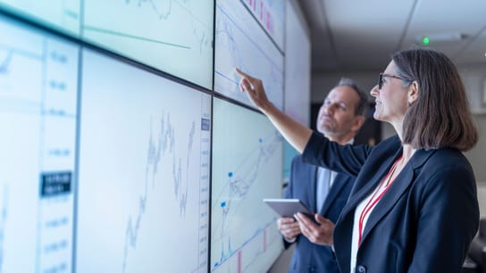 UK, York, Business people working with charts on interactive screens.