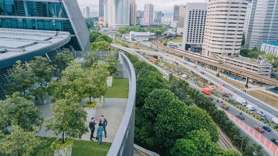 Three business person talking on roof top garden outside office building