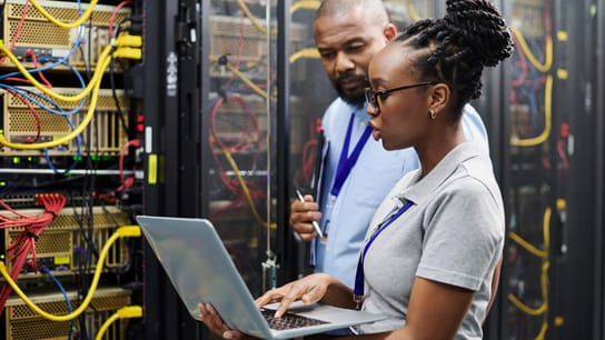 Shot of two technicians working together on a laptop in a server room. Developing an action plan for improved operations