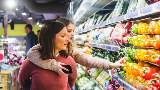 A woman and her little girl buying groceries in a supermarket