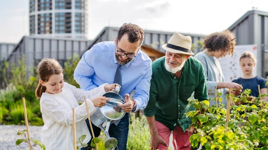 Nachbarn, die sich gemeinsam um ihren Gemeinschaftsgarten in einer Stadt kümmern.