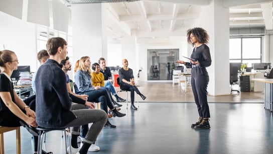 El futuro de la confianza: una joven comparte sus opiniones con su equipo en una reunión de oficina.