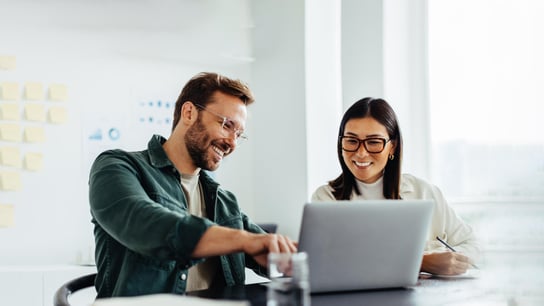 Hai người ngồi sau máy tính xách tay.
