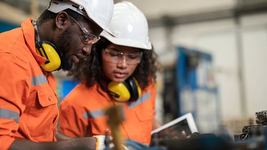 Two engineers having discussion on welding jig assembly to tolerance variations in the product parts.