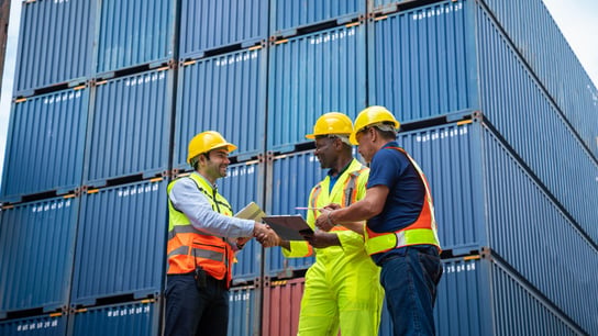 Ingénieur industriel et contremaître contrôlant un conteneur dans l’entrepôt d’un parc à conteneurs.