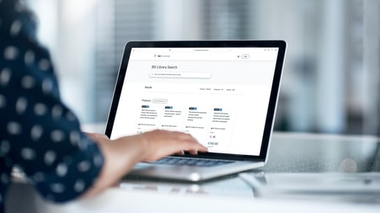 لقطة مجتزأة لسيدة أعمال تستخدم حاسوباً محمولاً على مكتبها
