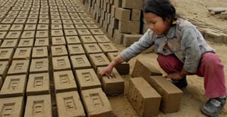 Small children doing grueling work in brick-making factories