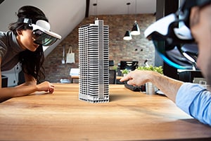 Two people using mixed reality headsets to work together