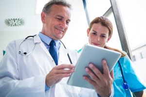 Doctor holding a tablet and having a conversation with nurse