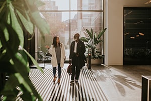 Two people walking and talking in a office building