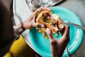 Person eating burger above plate