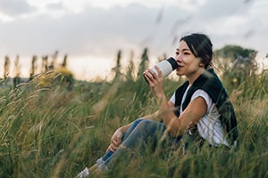 Woman drinking with reusable cup