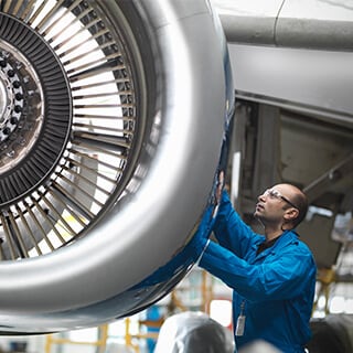 Ingenieure, die an einem Jet im Flughafen arbeiten