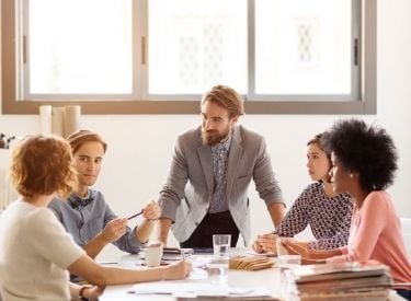 man-leaning-on-table-during-meeting