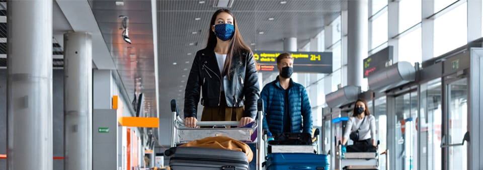 Personas en el aeropuerto con mascarillas