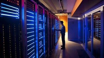 Fallstudien - ISO/IEC 27001 Serverraum in blau mit Mitarbeiter