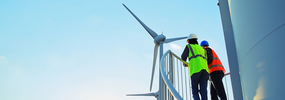 Wind Turbinen und zwei Mitarbeiter mit Warnwesten