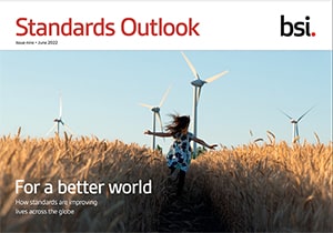 Girl running through field with wind turbine