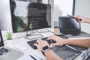 Person coding on desktop computer