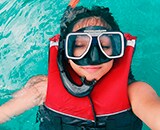 Frau in Schwimmweste mit Taucherbrille