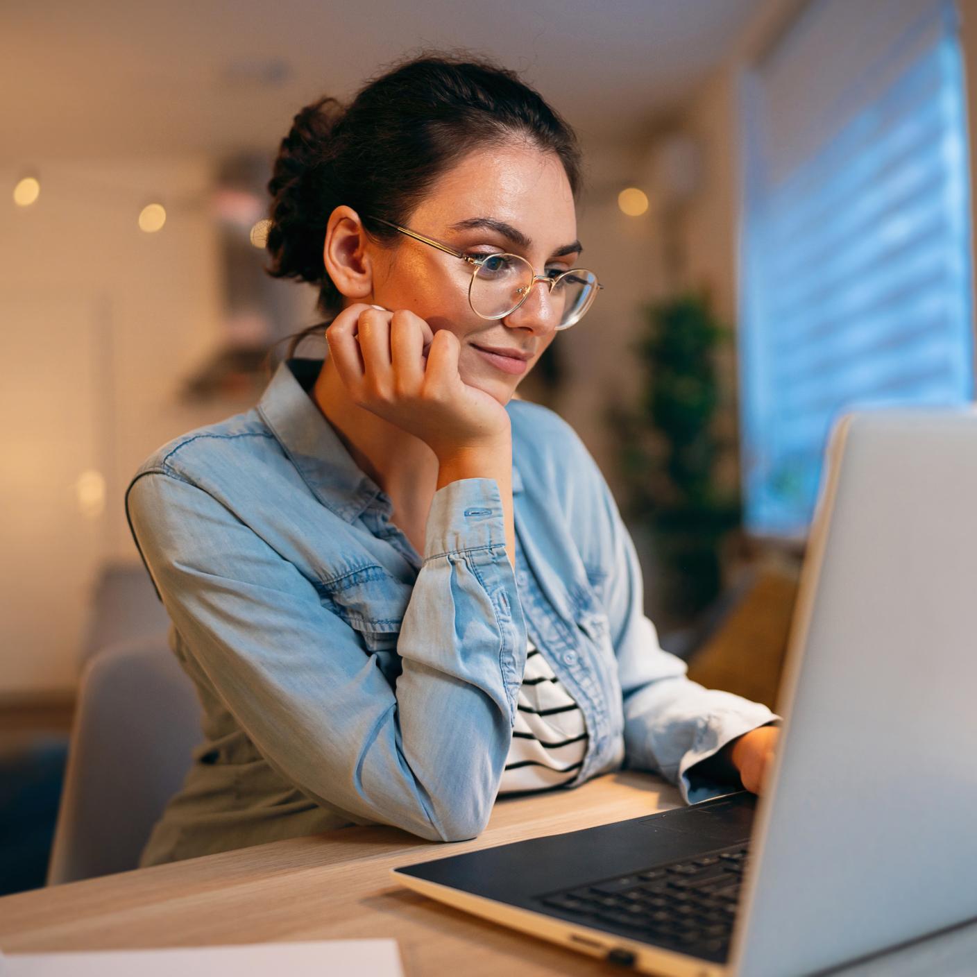 Modern young Caucasian woman, using laptop, while working or studying at home, enjoying the single life