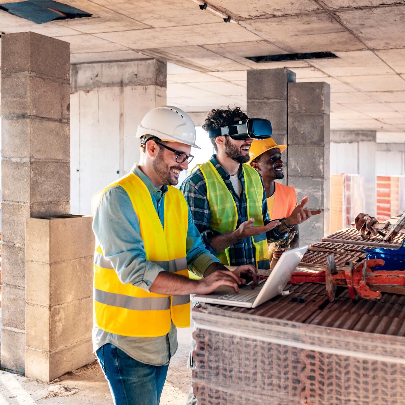 Engineering team in a building under construction using virtual reality goggles and computers