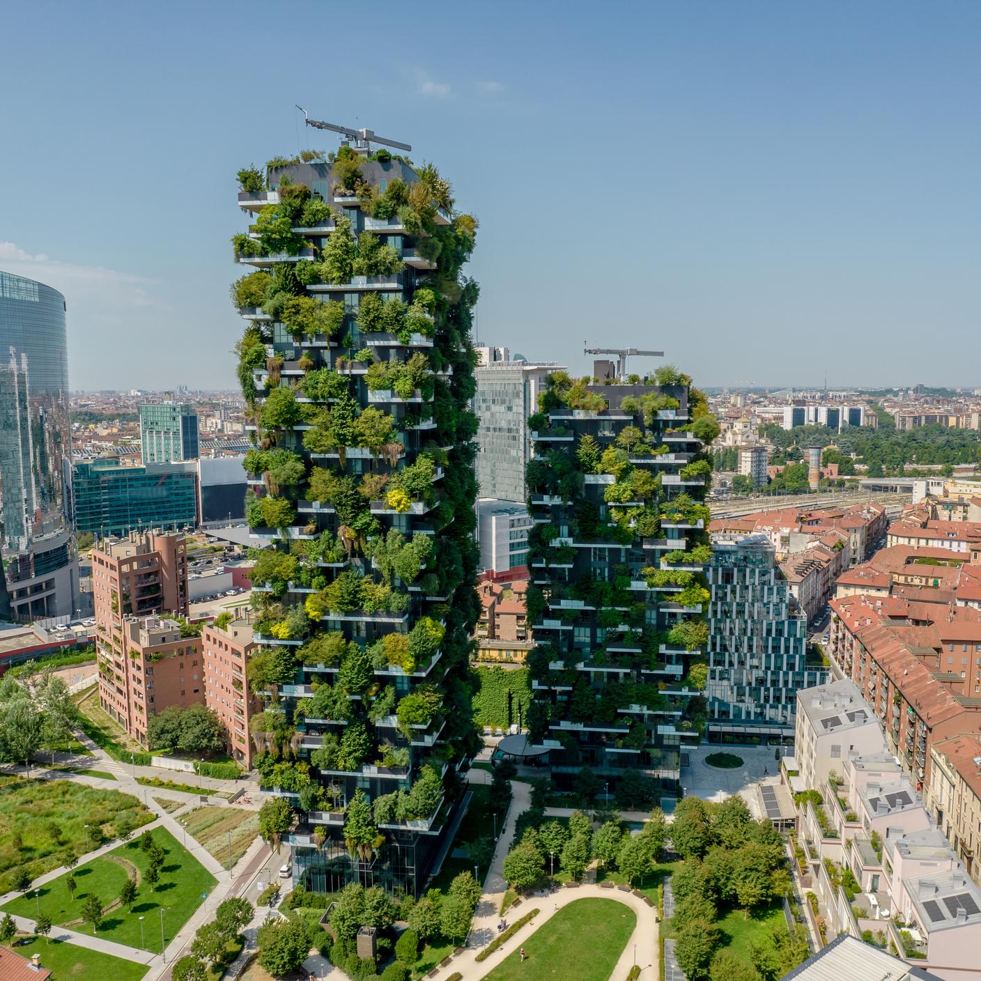 Aerial of buildings with many trees and other plants in balconies