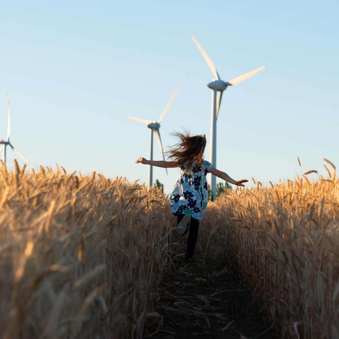 Future of energy : A little girl running in a field