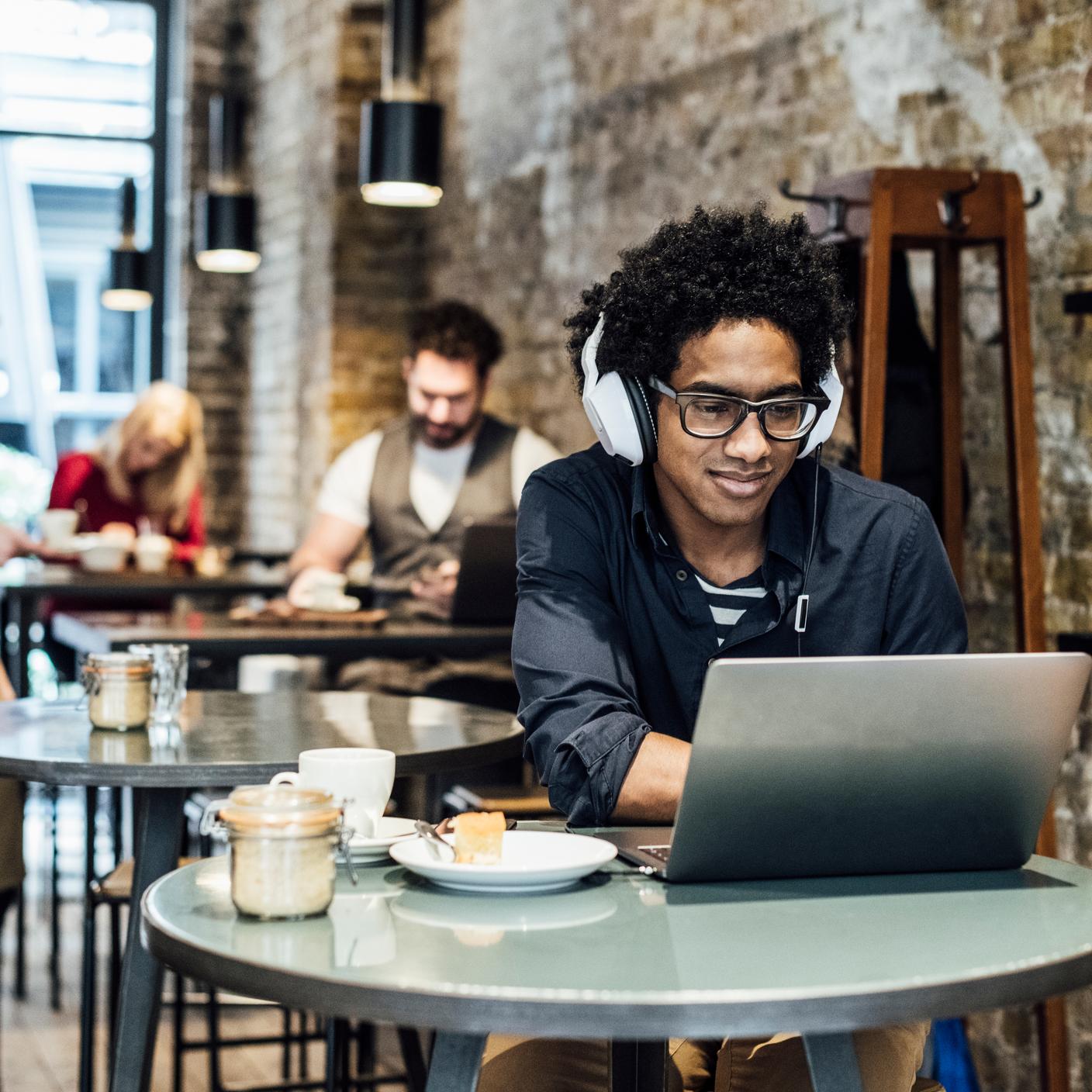 Cybersecurity - man in coffee shop using laptop