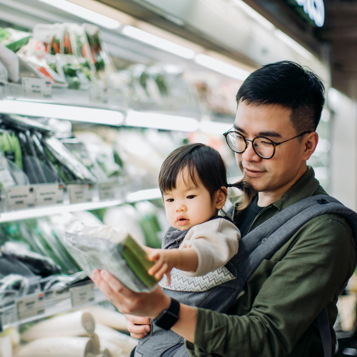 Father with little daughter grocery shopping for fresh organic vegetables