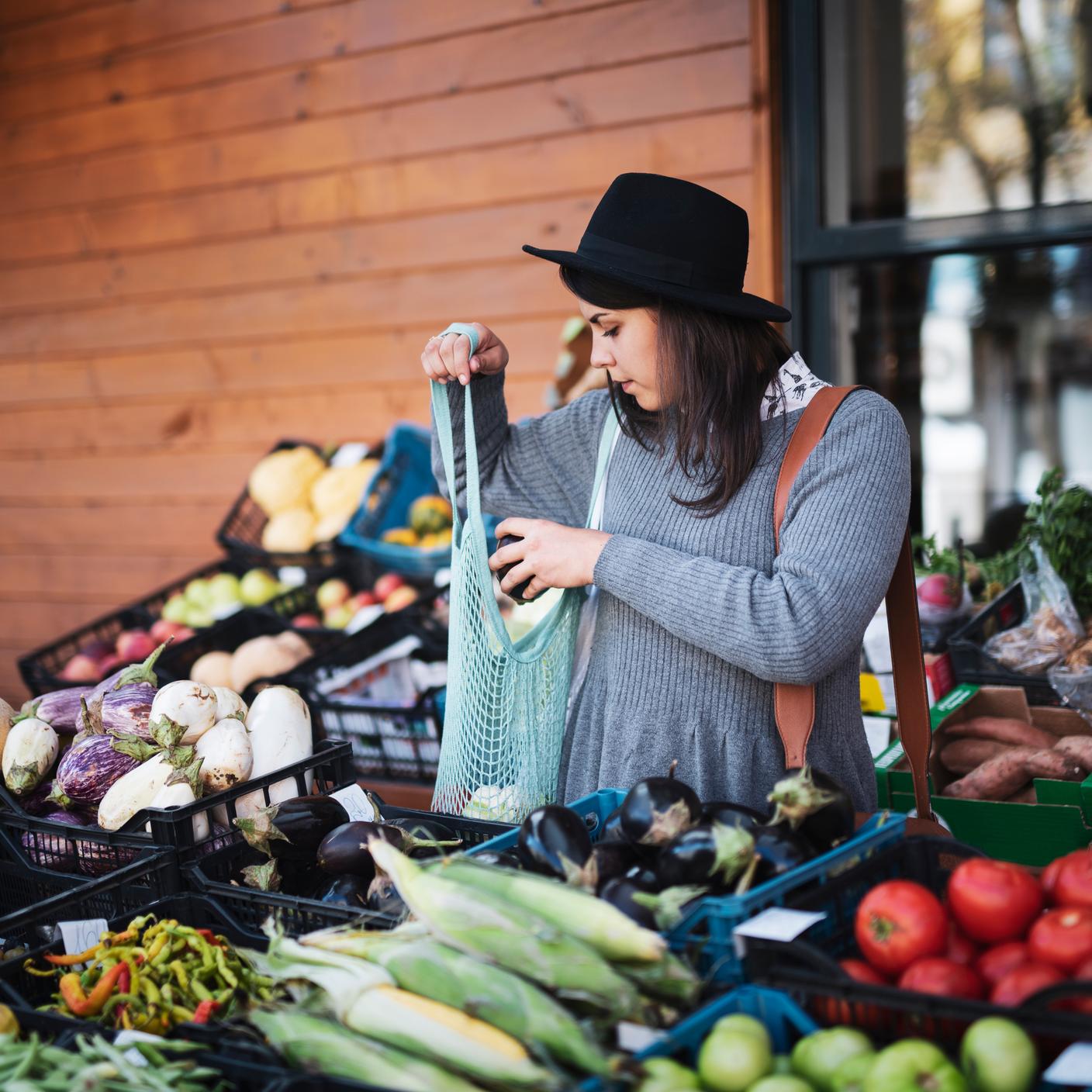 Enhancing Customer Satisfaction - Young woman buying fruit and vegetables at outside market