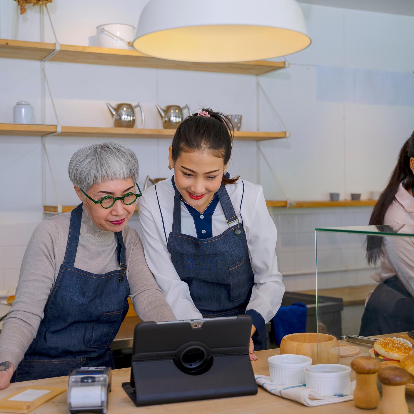 Two woman looking at a screen in their shop