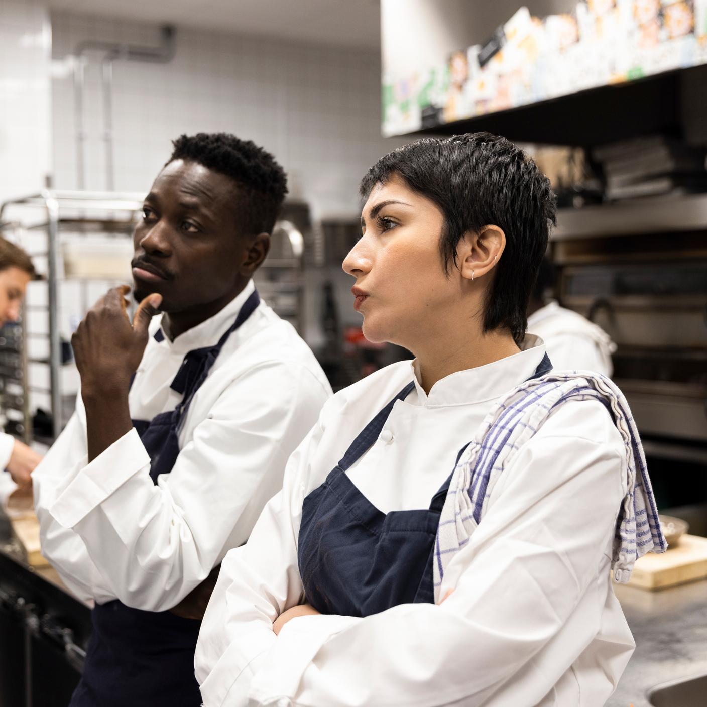 Driving business improvement - Male and female colleagues brainstorming in restaurant kitchen