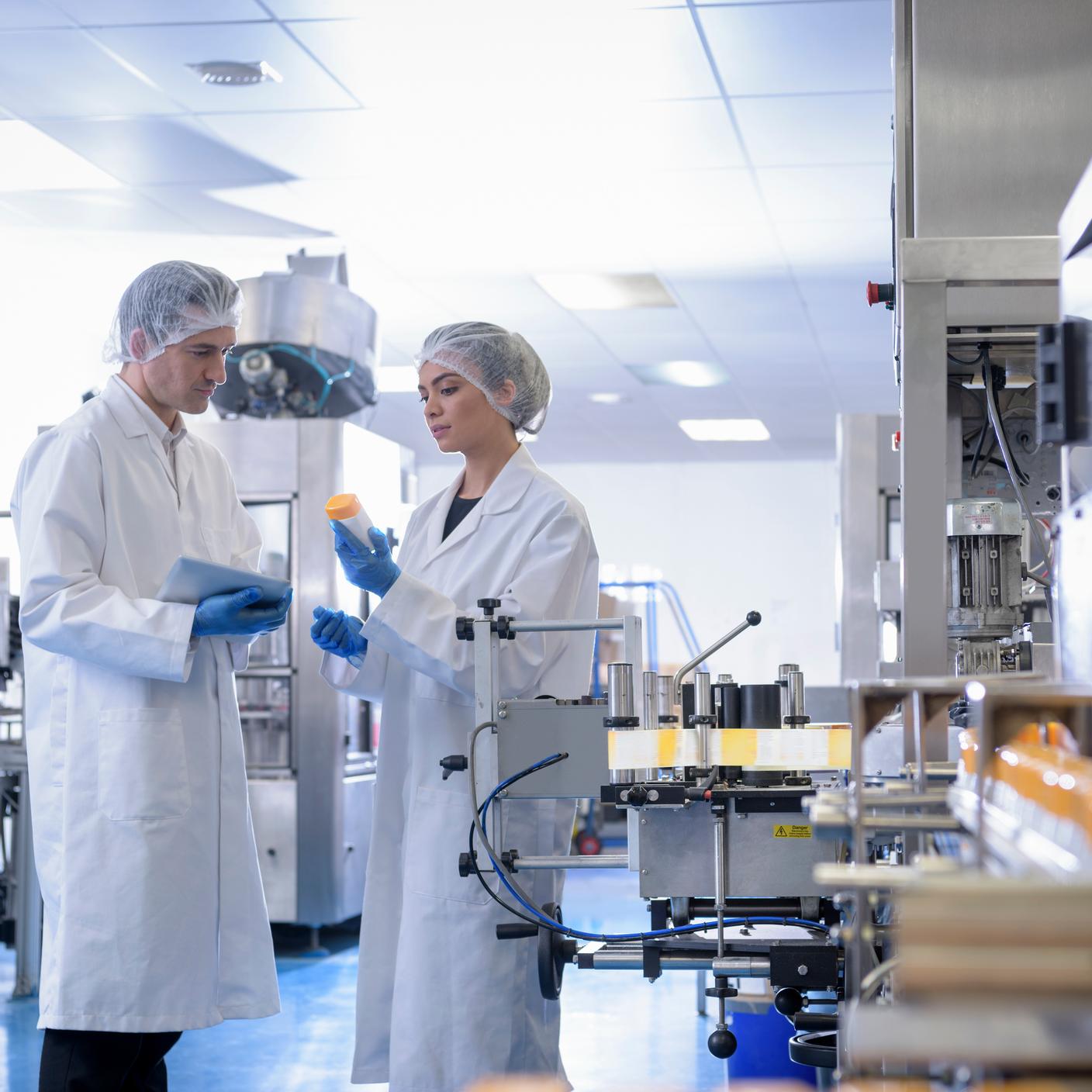 The role of standards in shaping workplace safety - Workers inspecting product in pharmaceutical factory