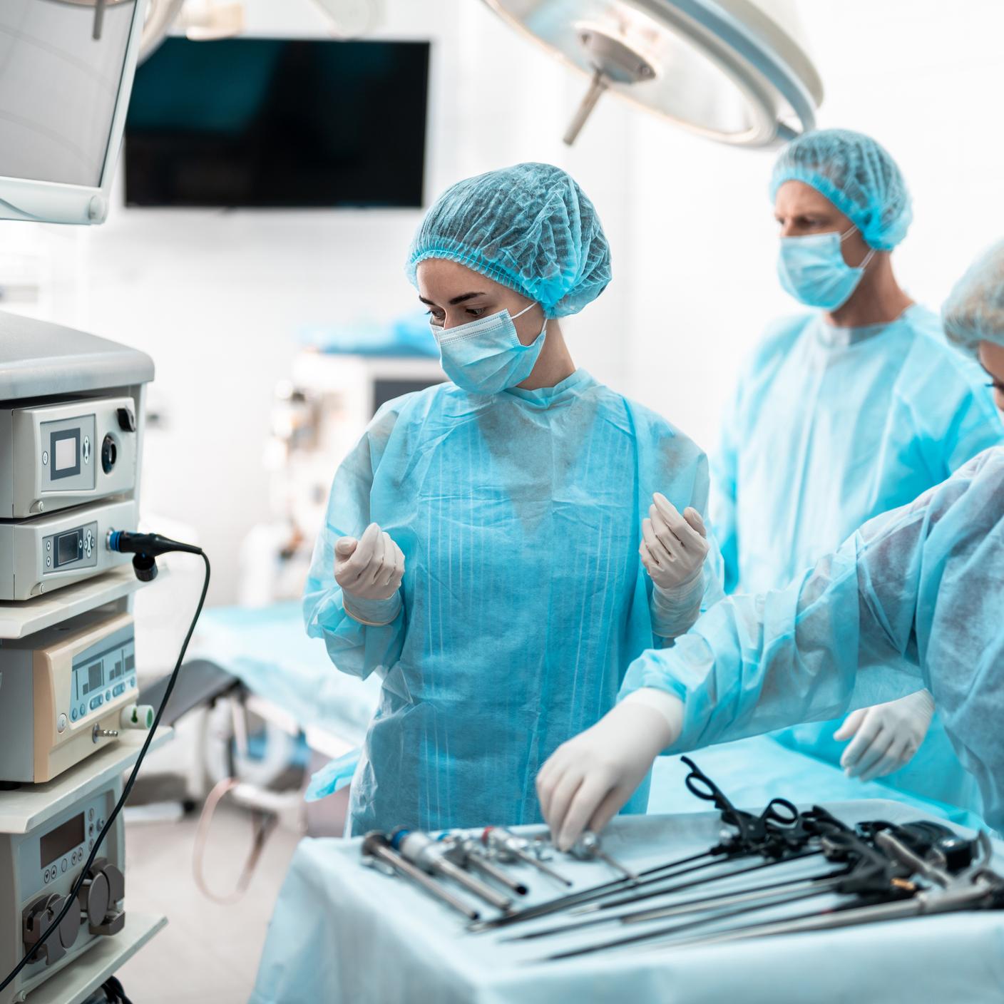 compliance management - portrait of nurses in masks checking laparoscopic instruments