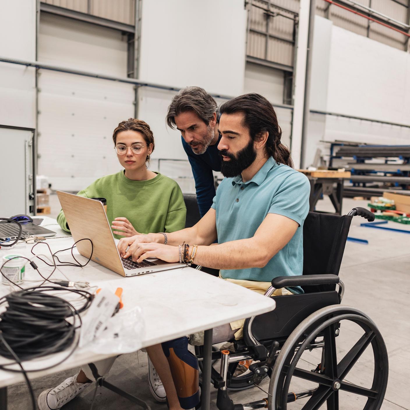 Engineer sitting in wheelchair working with colleagues