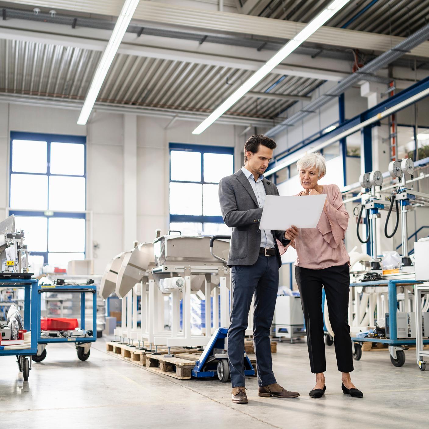 Coworkers looking at plan in a factory