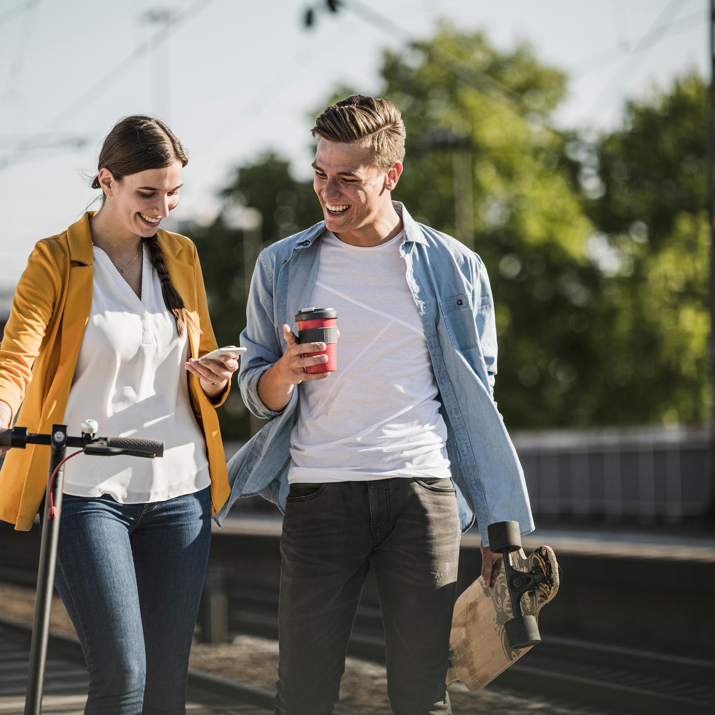 Sustainability in the built environment - man and woman using smartphone at train station