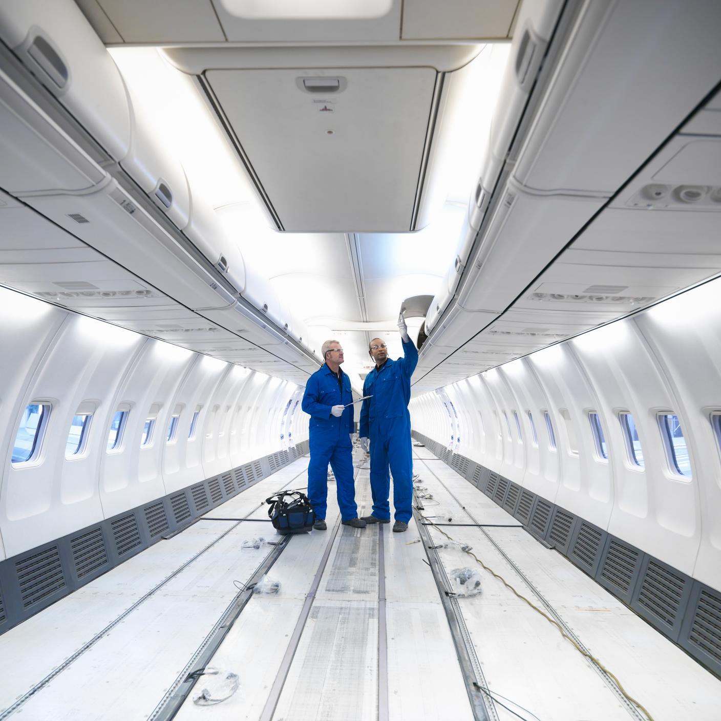 Aircraft engineers working on interior of 737 jet airplane