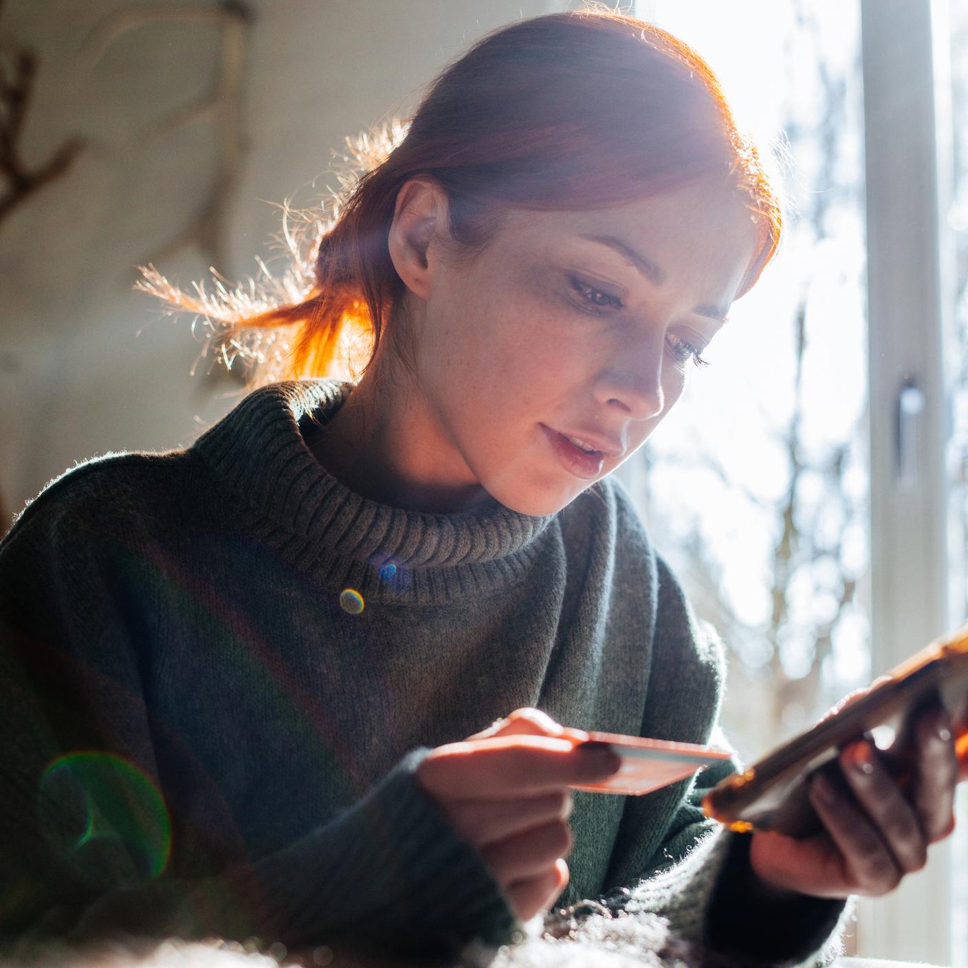 Woman shopping online with laptop and credit card on hand