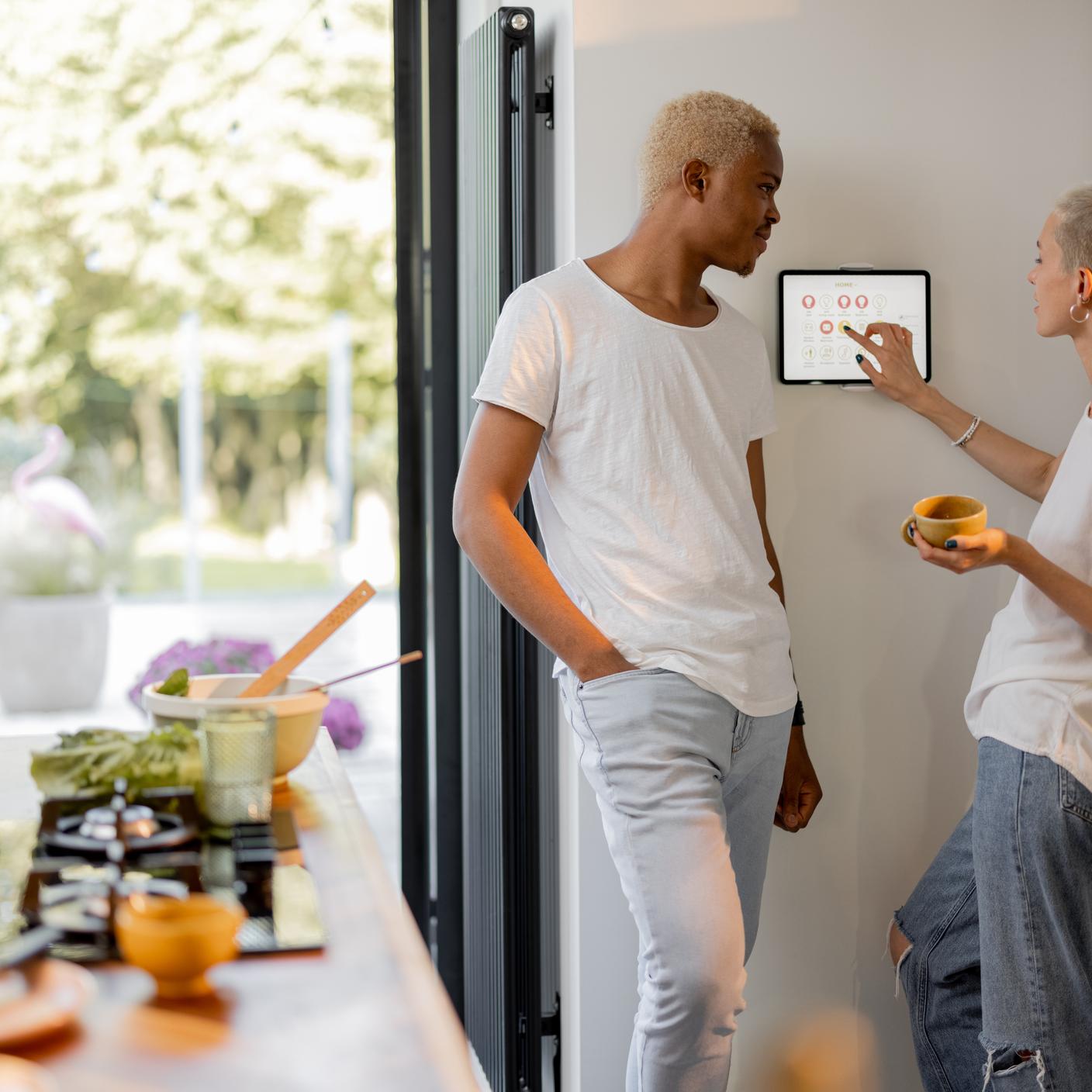 Couple choosing temperature on thermostat while cooking
