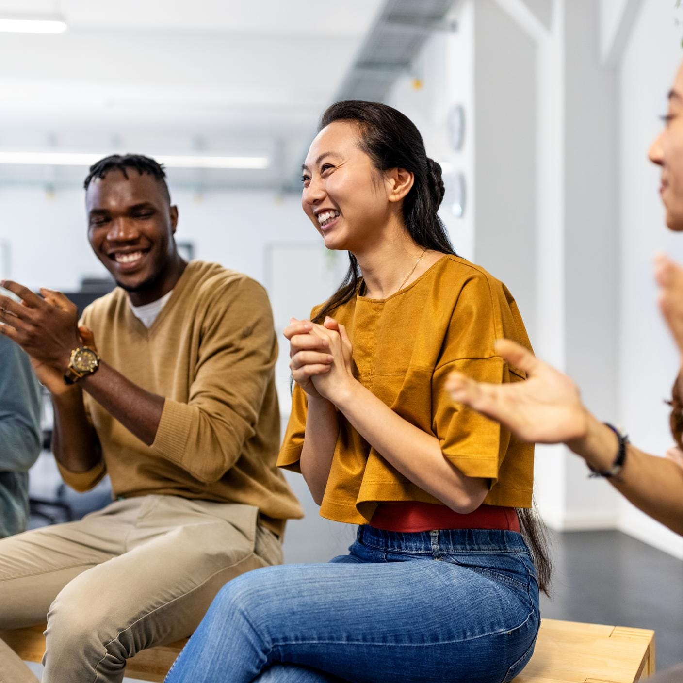 Multiracial business team applauding after a successful staff meeting.